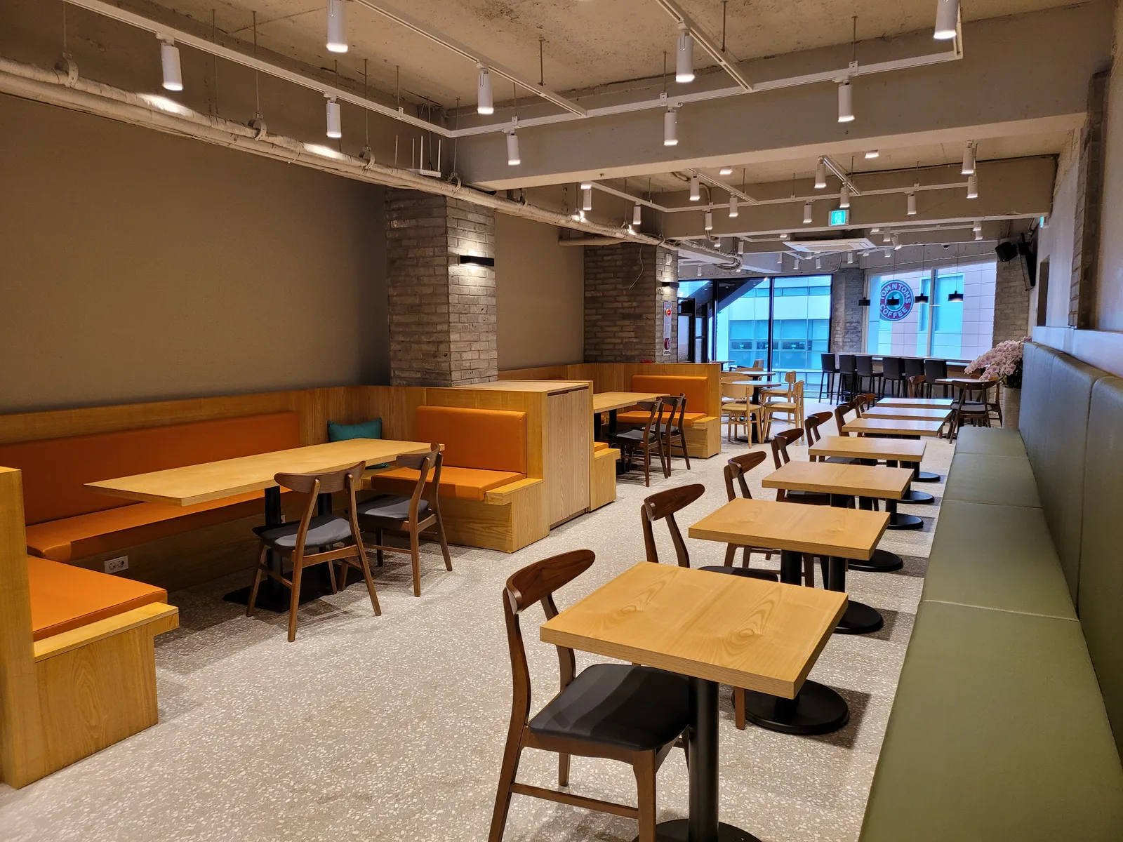 검정 프레임 칸막이와 2인 좌석으로 구성된 탐앤탐스 2층 스터디존